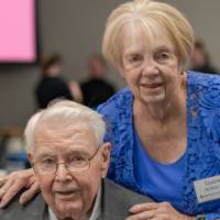 Galene DeWitt standing behind Peter DeWitt, smiling for camera